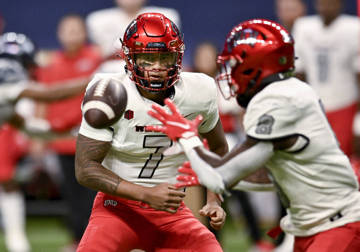 UNLV quarterback Cameron Friel (7) tosses the ball to running back Charles Williams during the ...