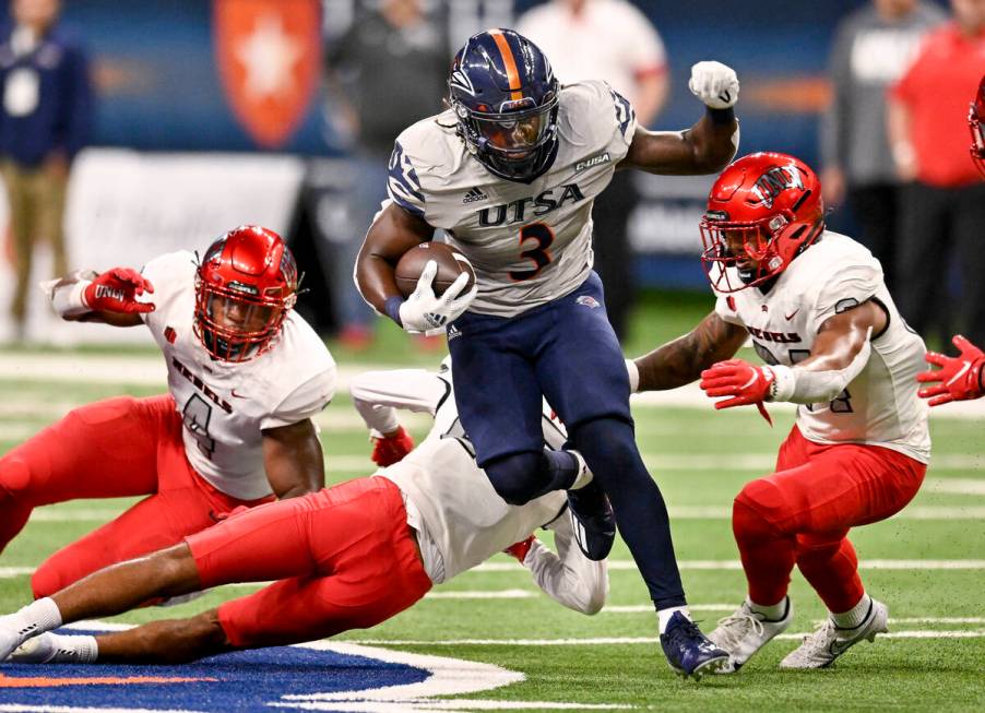 UTSA's Sincere McCormick (3) attempts to evade UNLV's Bryce Jackson, right, Jacoby Windmon, lef ...