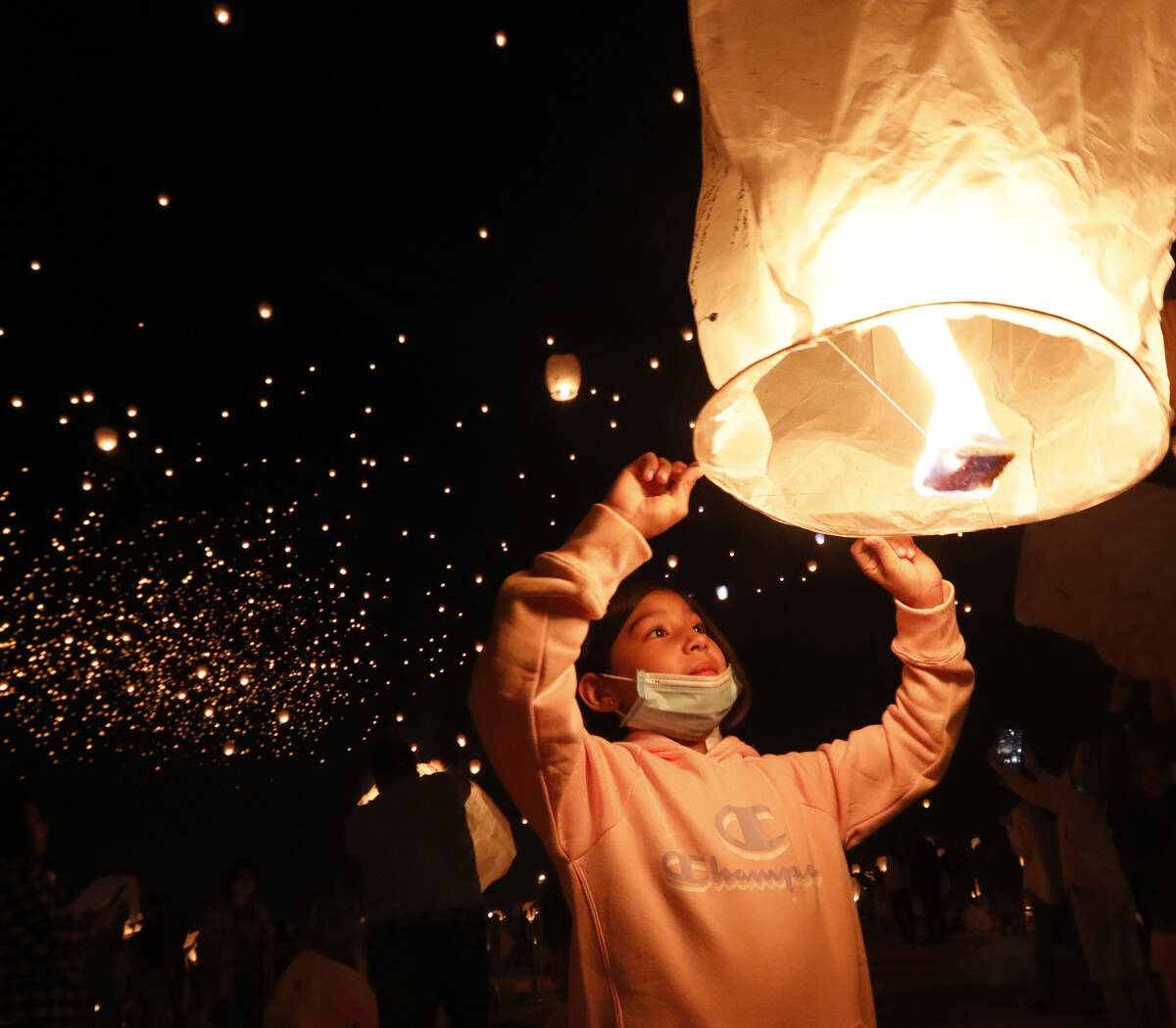 Allexa Garcia, 8, of Los Angeles prepares her lantern for launch at the Rise Festival in the Mo ...