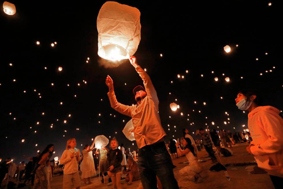 Guillermo Garcia of Los Angeles , center, releases his lantern at the Rise Festival in the Moja ...