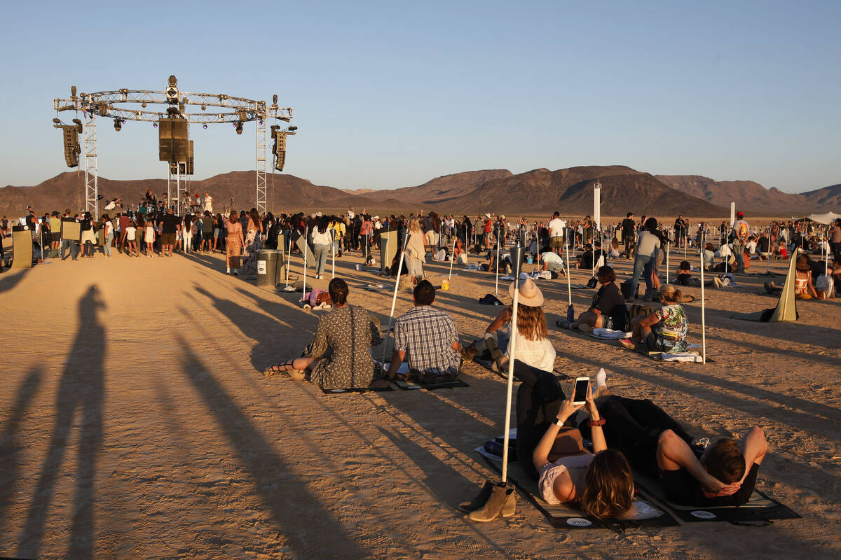 Participants listen music and wait for launch their lanterns at the Rise Festival in the Mojave ...