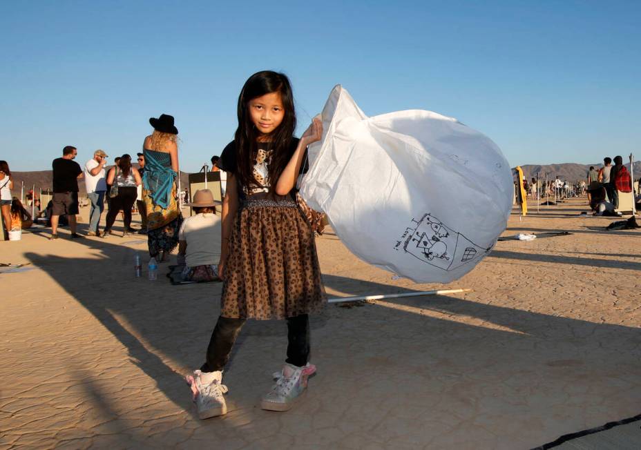Yumi Yuan, 8, of Los Angles shows her lantern at the Rise Festival in the Mojave Desert, Nev, S ...