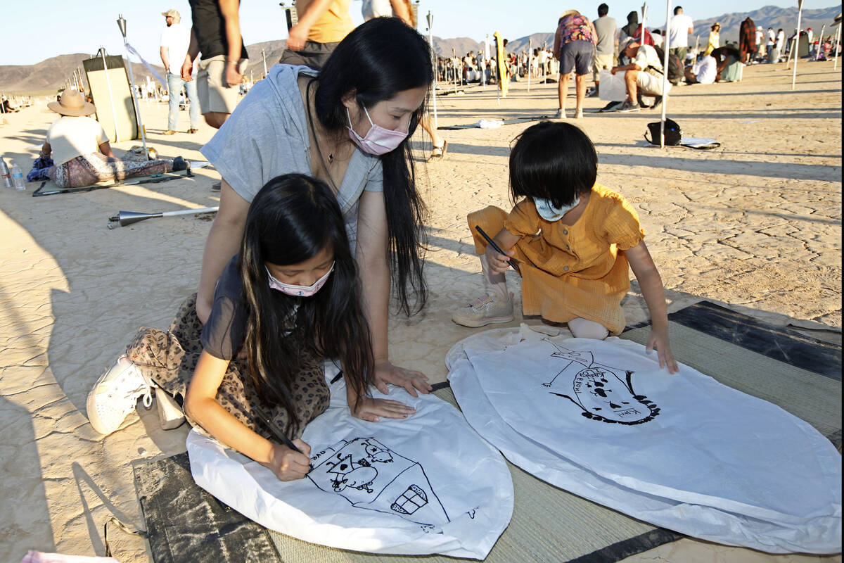 Yumi Yuan, 8, of Los Angles, left, and her sister Kimi Yuan, 4, right, draw pictures on their l ...