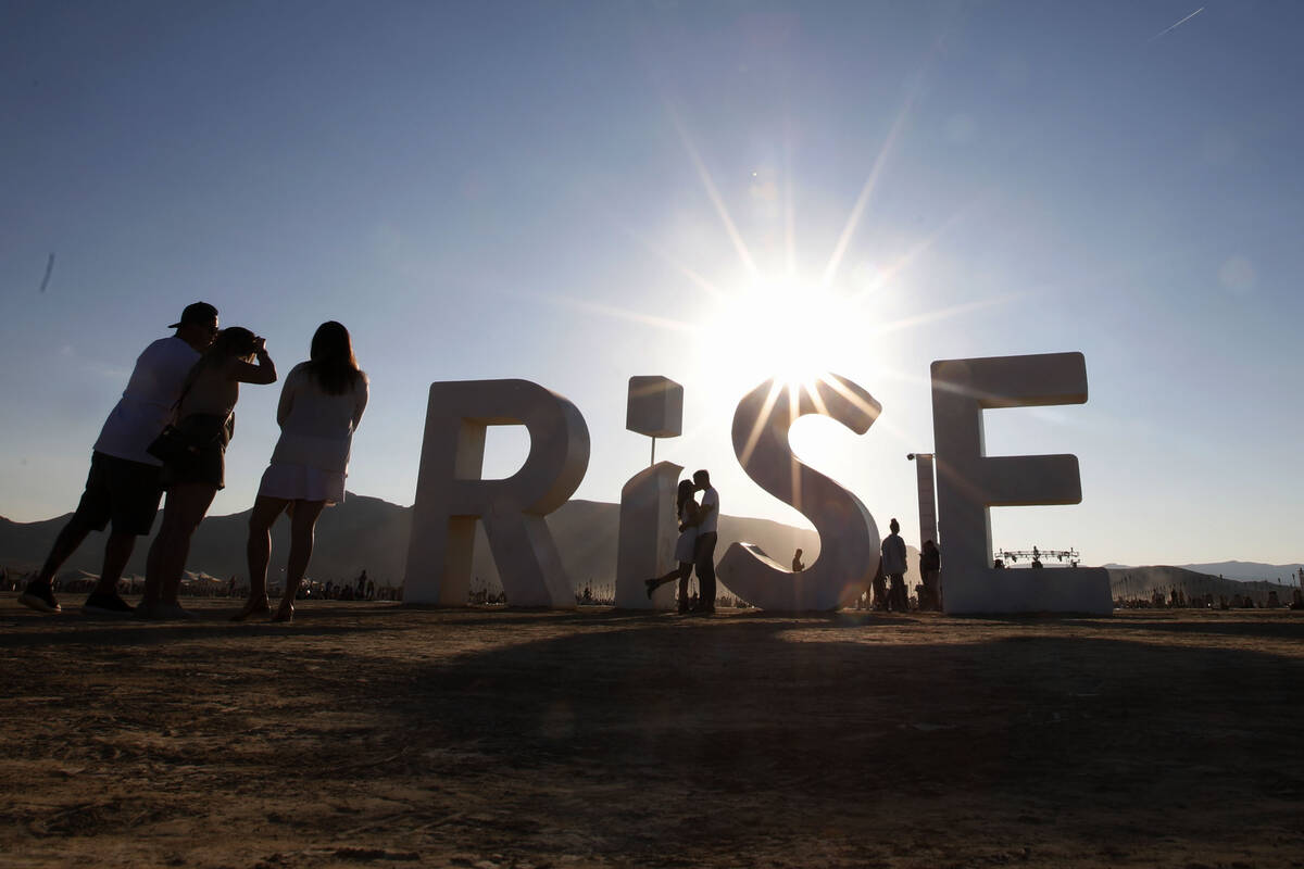 Tri Phan kisses his fiance Ashley Ngeth, both from San Diego at the Rise Festival in the Mojave ...