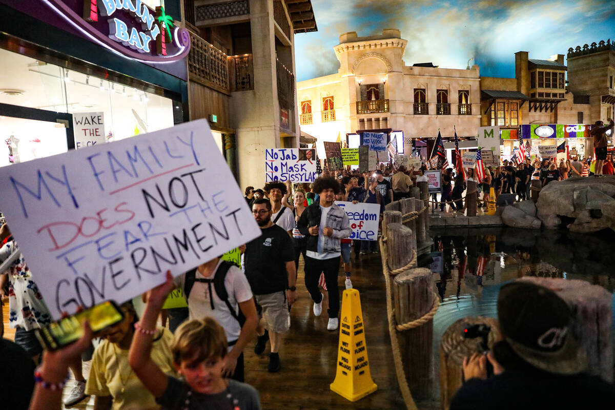 Protestors walk through the Miracle Mile shops to protest COVID-19 government mandates, hosted ...