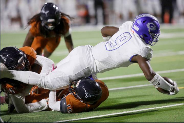 Bishop Gorman High School's Elija Lofton (9) scores a touchdown over Legacy High School's Noasa ...