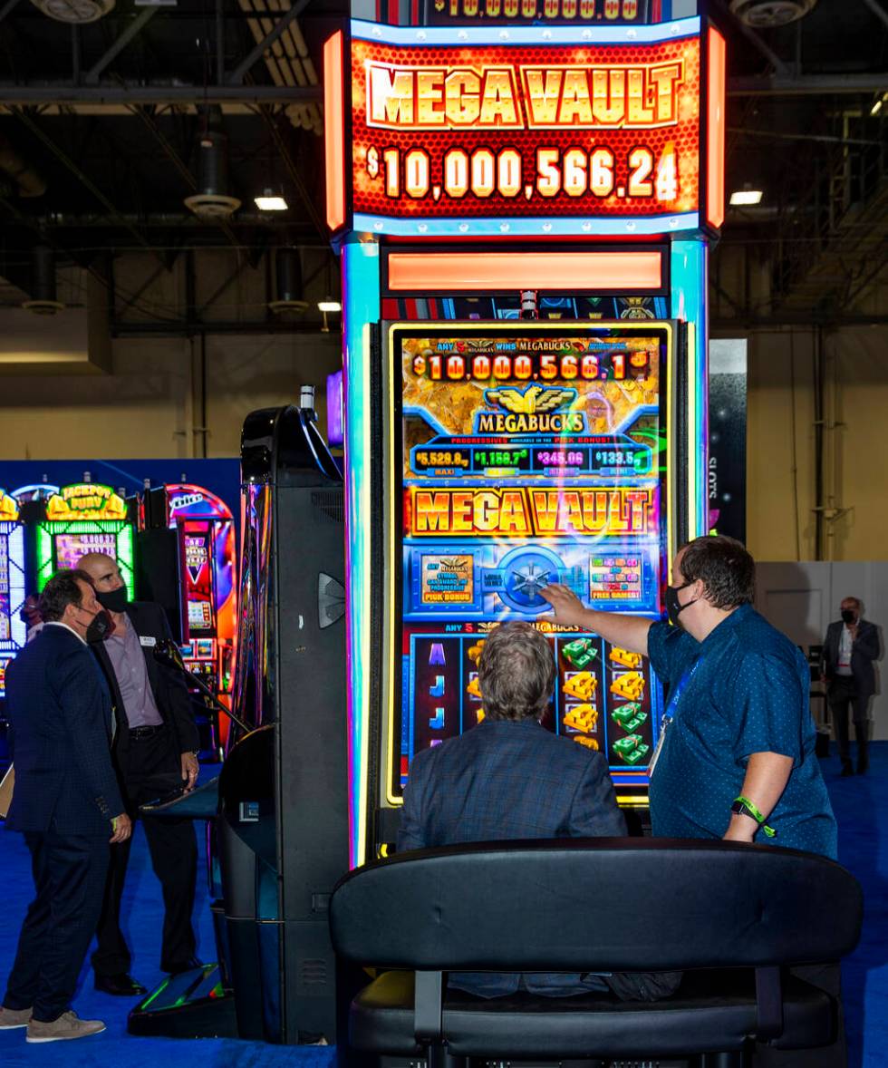 Dan Digre, left, gets a visual tour of an IGT Mega Vault game from Tyson Brandes during day 3 a ...