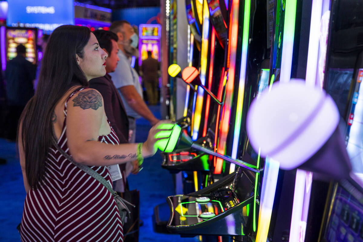 Attendees play slot games in the IGT display space during day 3 at the Global Gaming Expo 2021 ...