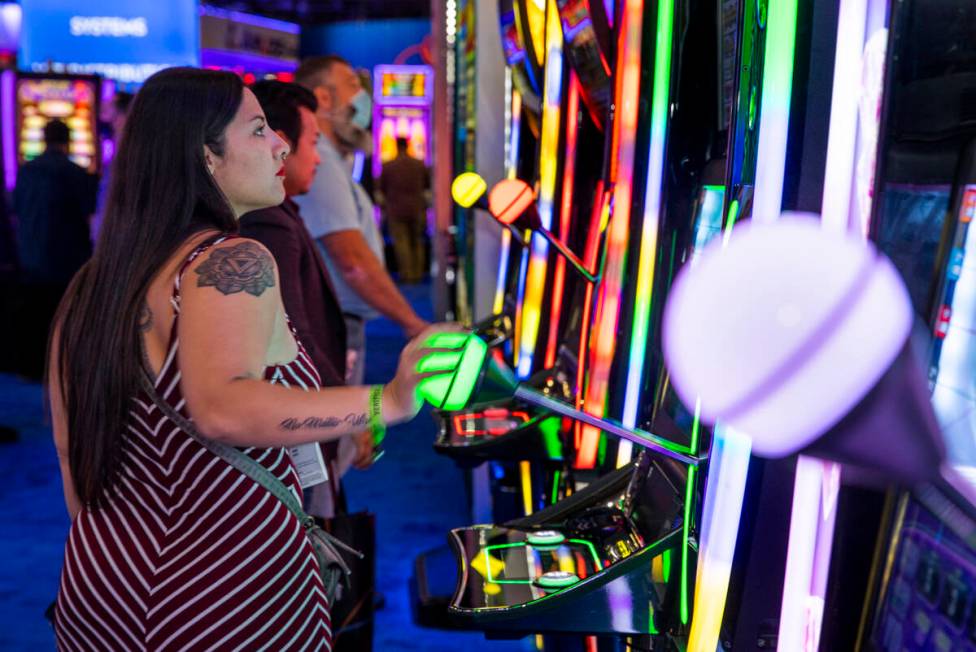 Attendees play slot games in the IGT display space during day 3 at the Global Gaming Expo 2021 ...