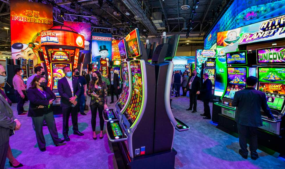 Attendees learn about the newest slot within the Scientific Games Corp. display area during day ...