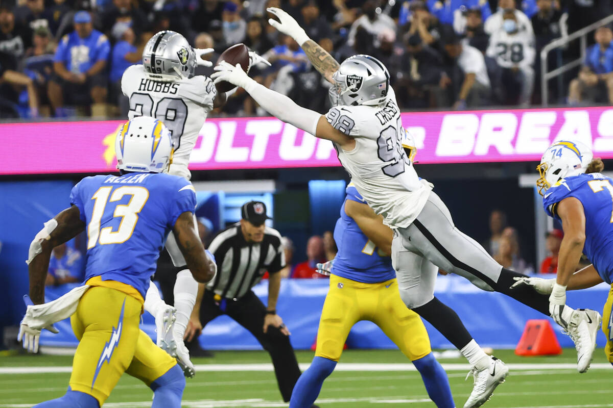 Raiders cornerback Nate Hobbs (39) and defensive end Maxx Crosby (98) block a pass from Los Ang ...