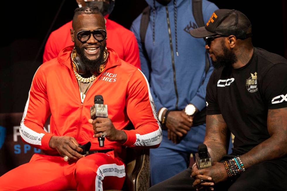 Deontay Wilder, left, speaks to his trainer Malik Scott during a press conference in advance of ...