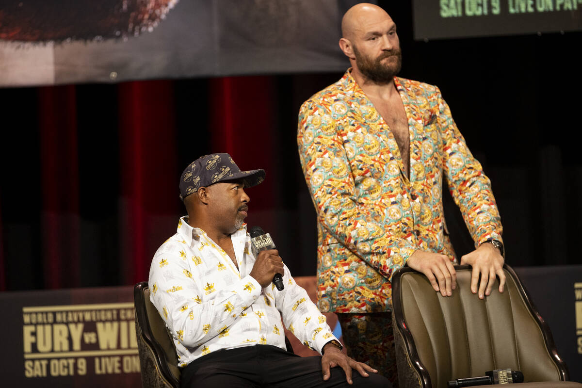 Tyson Fury, right, with his trainer Javan Steward, participate during a press conference in adv ...