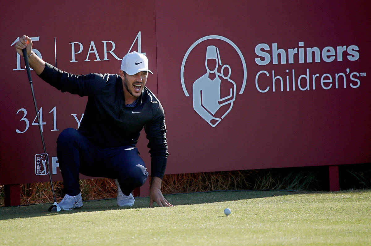Brooks Koepka stretches while waiting to tee off on the 14th hole during the Shriners Children& ...