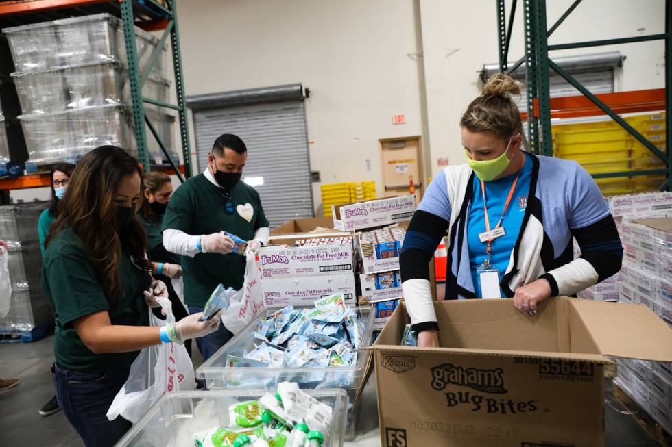 Lisa Curran, Three Square Food Bank development officer, stocks food for volunteers from the Sa ...