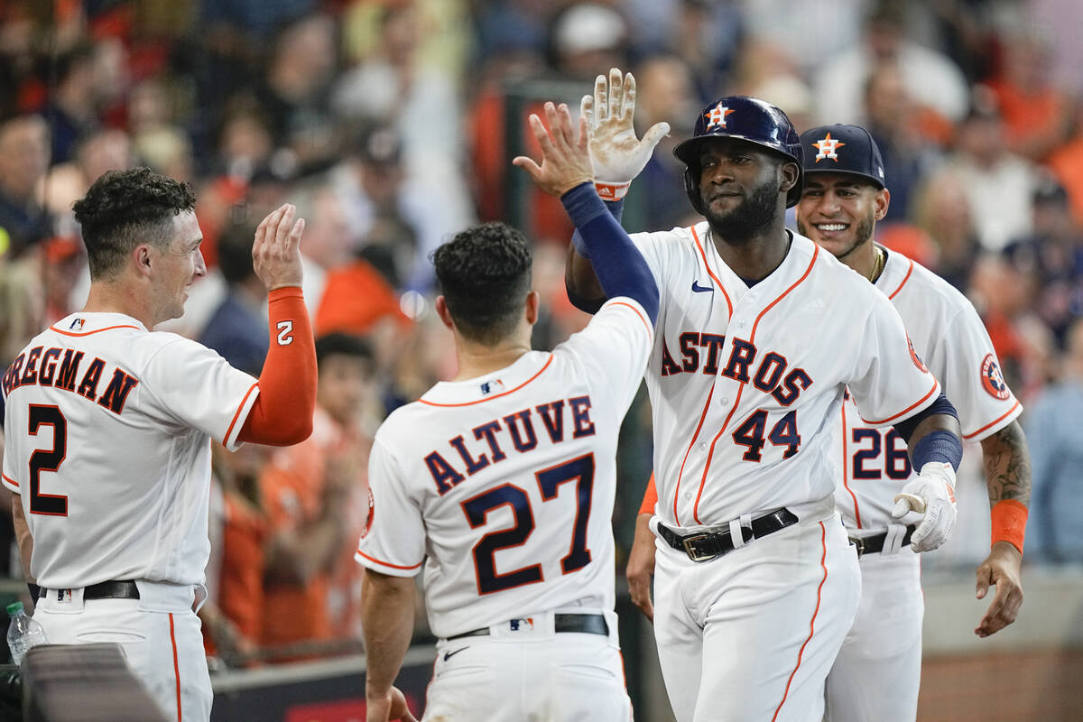 Houston Astros designated hitter Yordan Alvarez, second from right, is greeted by Alex Bregman ...