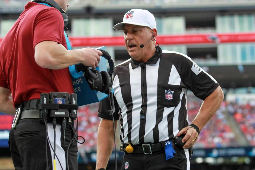 Referee John Hussey (35) reviews a play using instant replay during the first half an NFL footb ...