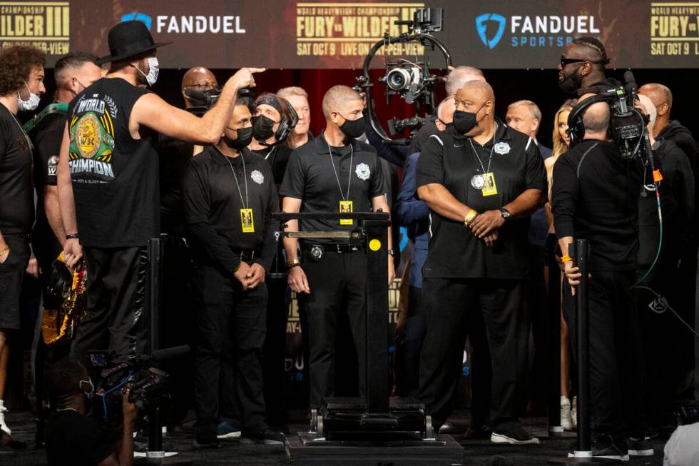 Tyson Fury and Deontay Wilder meet on stage during a weigh-in event at the MGM Grand Garden Are ...