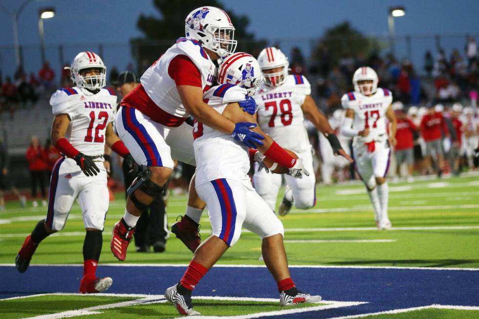 Liberty's Jayven Perez (95), right, celebrates his touchdown with teammate Jesse Wilson (75), i ...