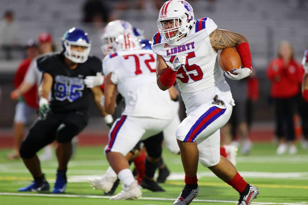 Liberty's Jayven Perez (95) runs the ball for a touchdown in the first half of a football game ...