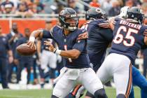 Chicago Bears quarterback Justin Fields (1) looks to pass the ball during the first half of an ...