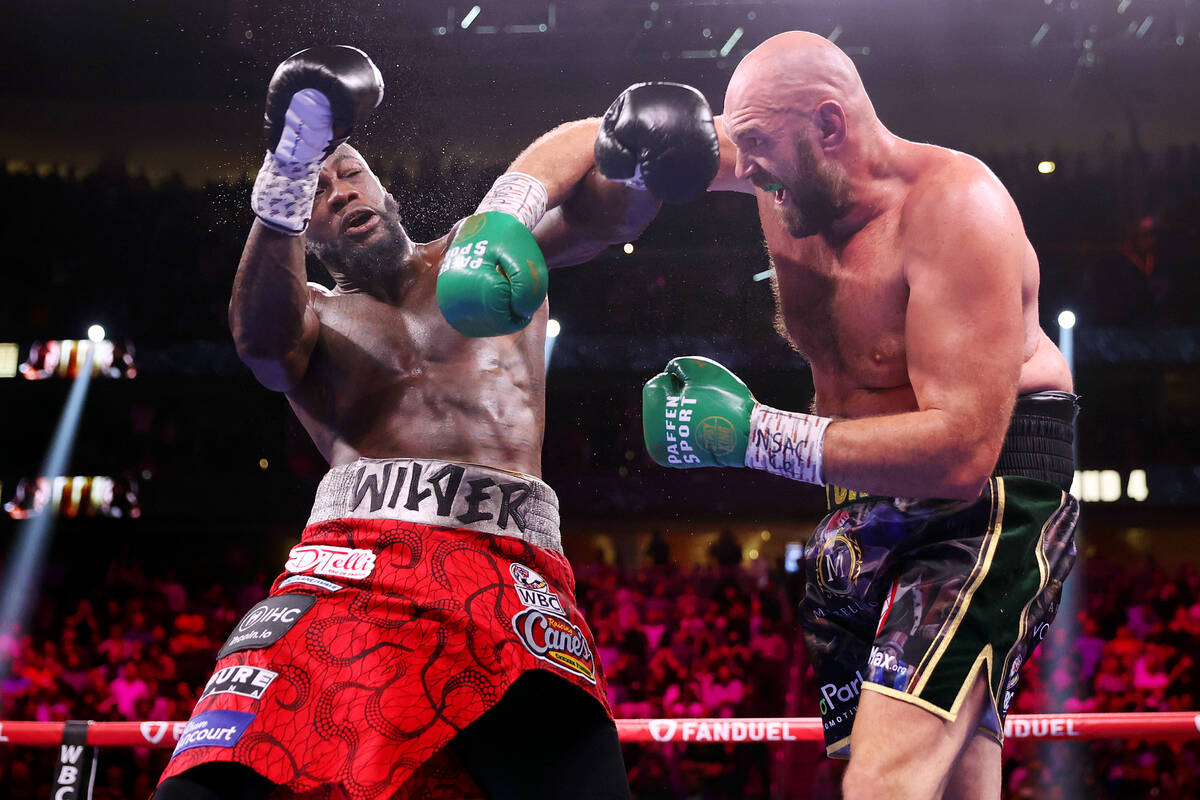 Tyson Fury, right, connects a punch against Deontay Wilder in the fourth round of a WBC Heavywe ...