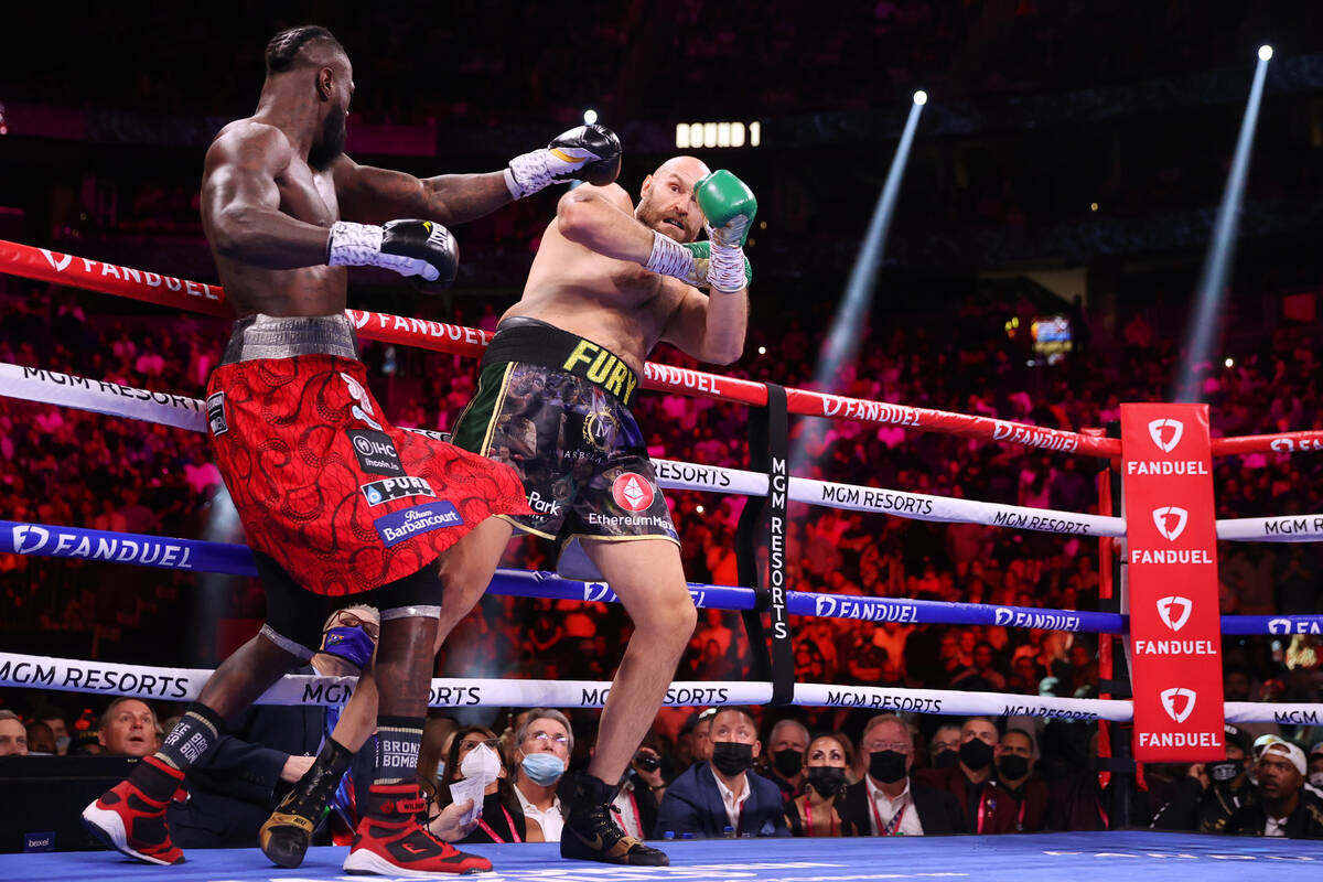 Deontay Wilder, left, and Tyson Fury, battle in the first round of a WBC Heavyweight World Cham ...