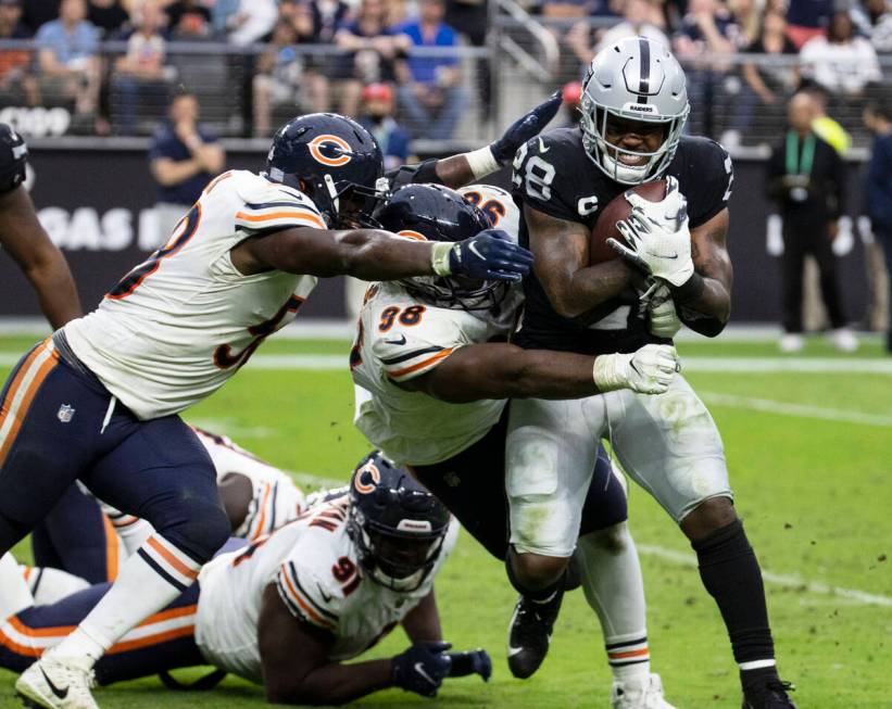 Raiders running back Josh Jacobs (28) tackled by Chicago Bears defenders during the second half ...