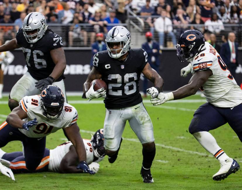 Raiders running back Josh Jacobs (28) eludes Chicago Bears defenders during the second half of ...