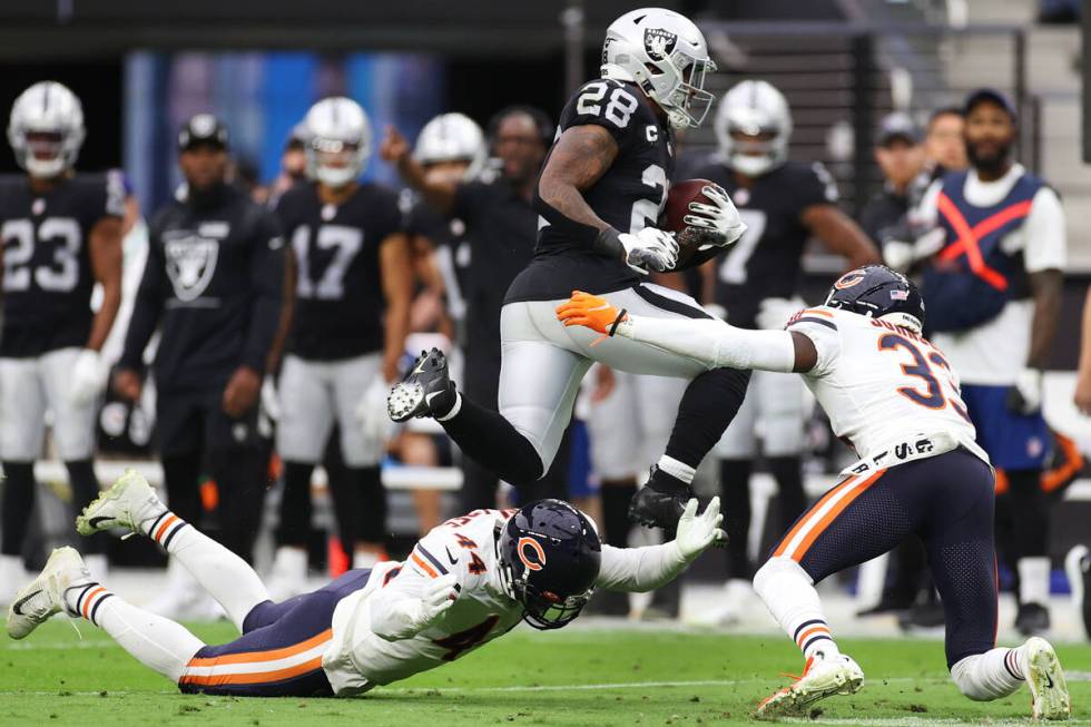 Raiders running back Josh Jacobs (28) leaps over Chicago Bears inside linebacker Alec Ogletree ...