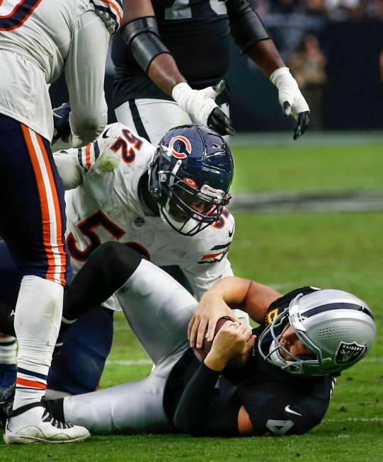 Chicago Bears outside linebacker Khalil Mack (52) looks down at Raiders quarterback Derek Carr ...