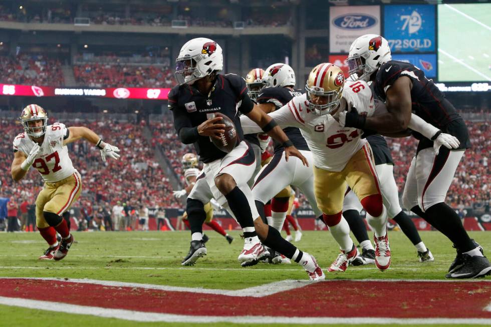 Arizona Cardinals quarterback Kyler Murray (1) eludes the reach of San Francisco 49ers defensiv ...