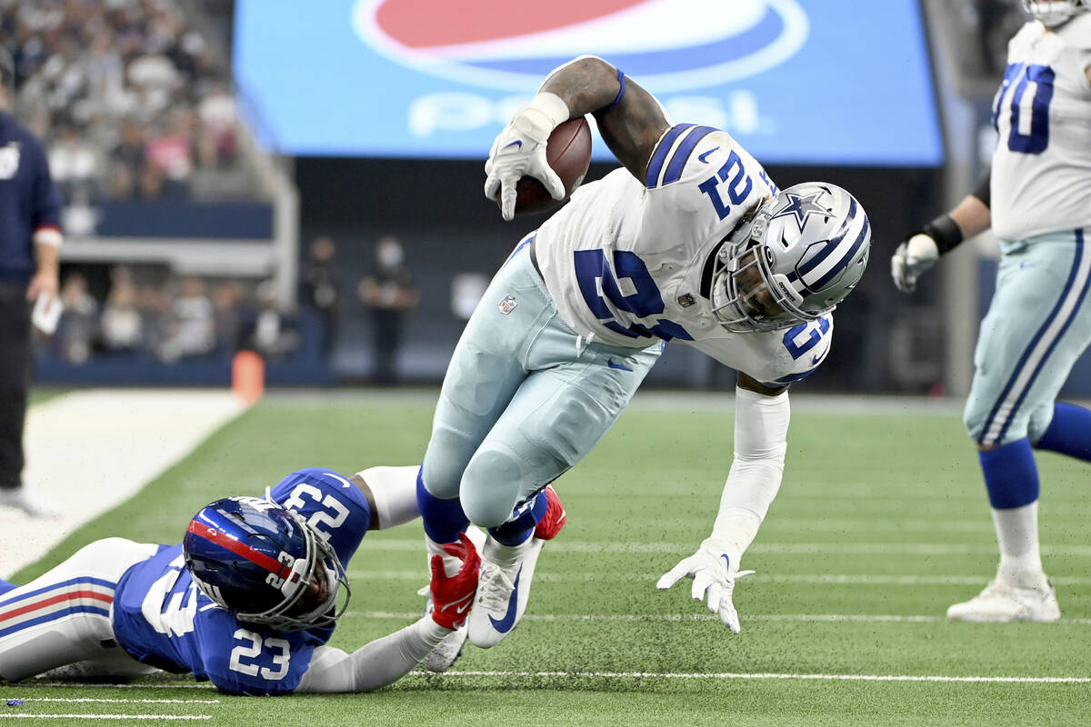 Dallas Cowboys running back Ezekiel Elliott (21) is tackled by New York Giants safety Logan Rya ...