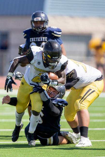 Clark running back Lebon Makwashi (2) is tackled by Cheyenne defensive lineman Vincent Carlton ...