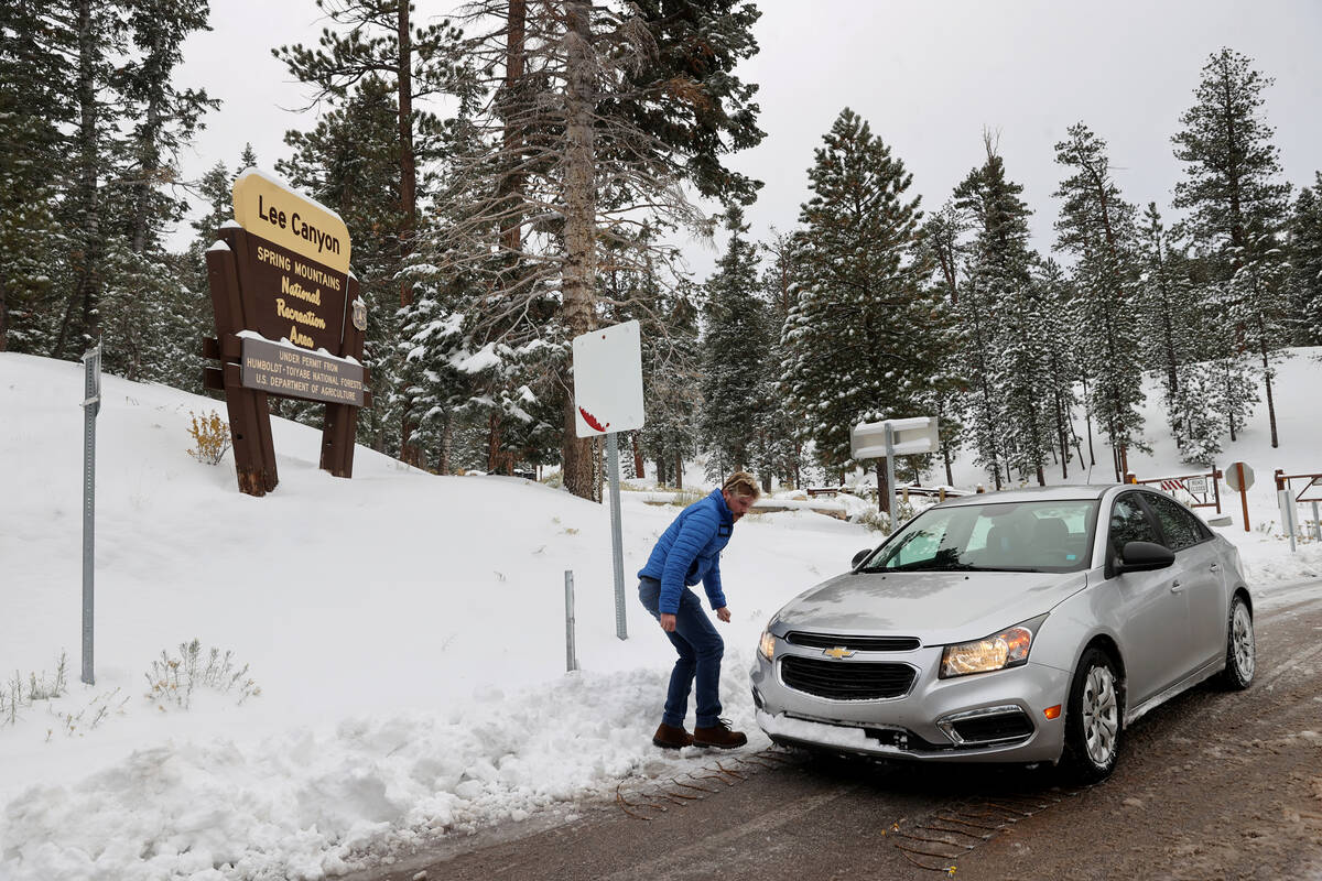 Garret Paus of Las Vegas puts tire chains on his car in Lee Canyon on Mount Charleston northwes ...