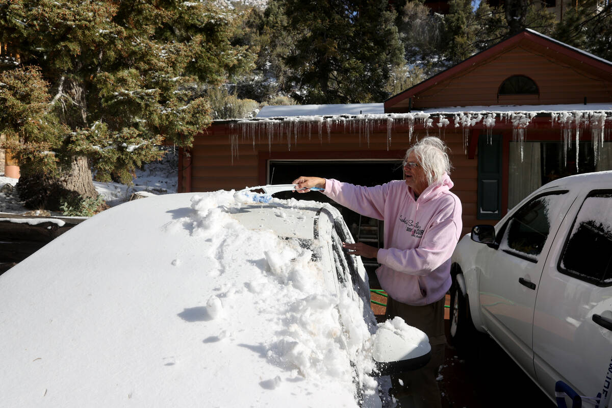Beni Talley cleans snow off his car at his house in Kyle Canyon on Mount Charleston northwest o ...