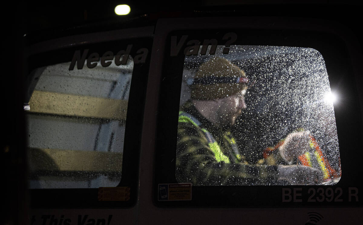 Workers prep gear in their van before starting to attempt to restore power during an outage at ...