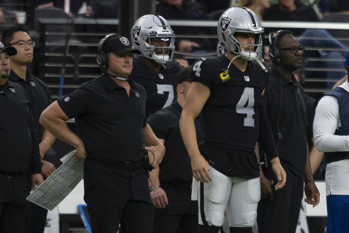 Raiders head coach Jon Gruden, left, looks on with Raiders quarterback Derek Carr (4) during th ...