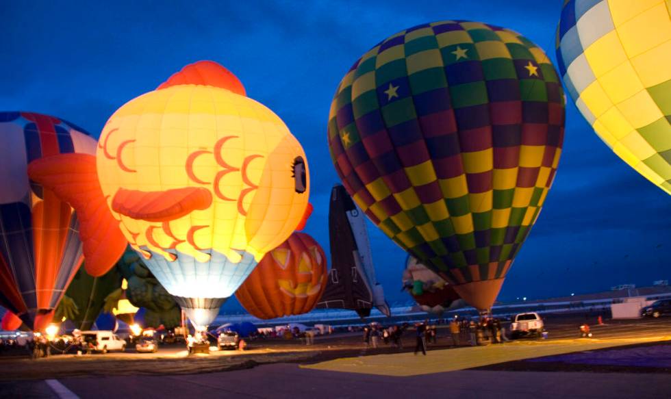 Hot-air balloons glow, as burners fire in preparation for the tethered "balloon glow" event. ( ...