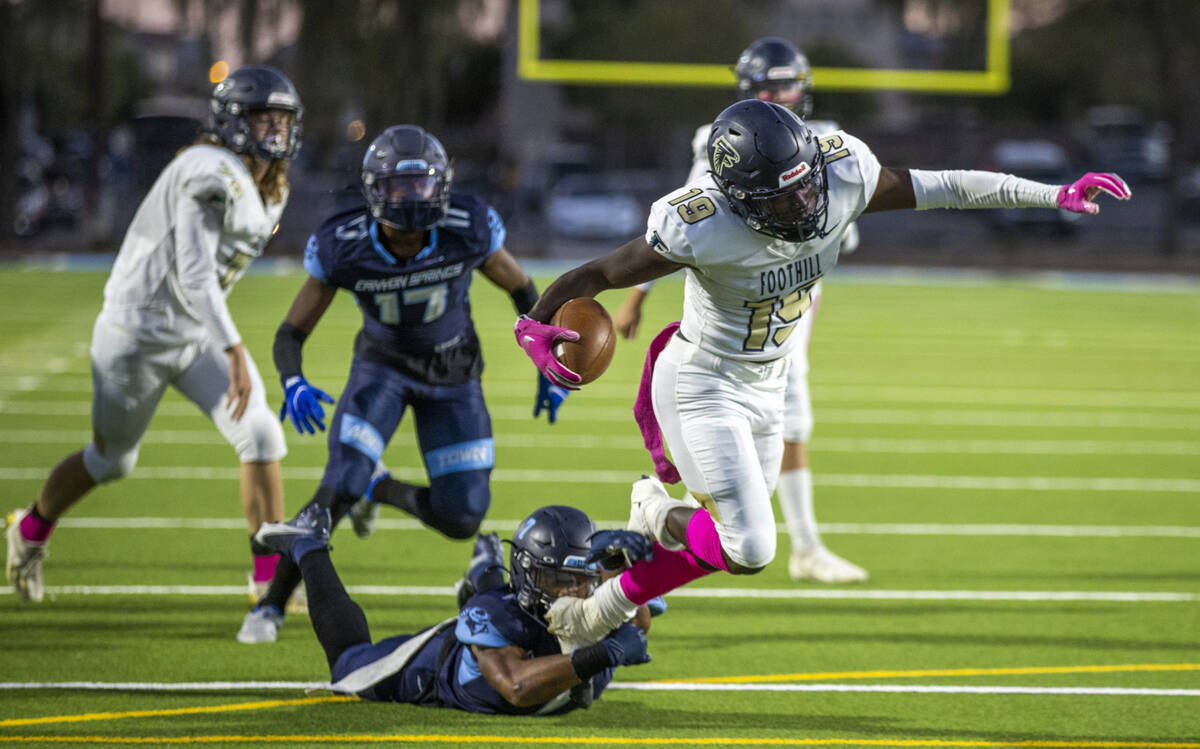 FoothillÕs Kendric Thomas (19) attempts to break a tackle attempts by Canyon SpringsÕ ...
