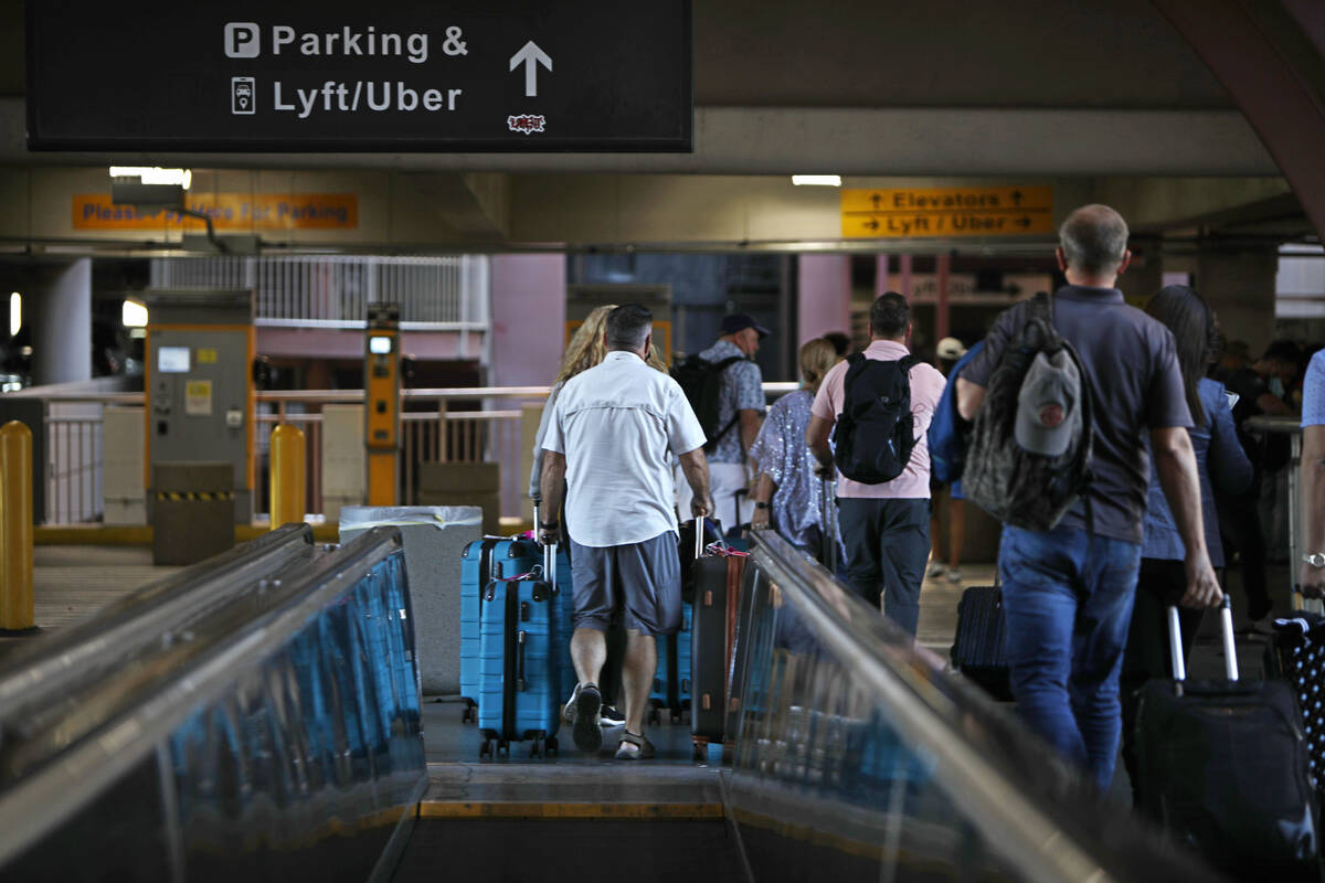 Arriving passengers walk to the parking lot of McCarran International Airport , Friday, Oct. 15 ...