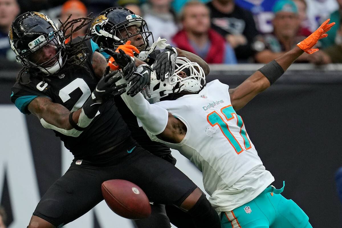 Miami Dolphins wide receiver Jaylen Waddle (17) is challenged by Jacksonville Jaguars free safe ...