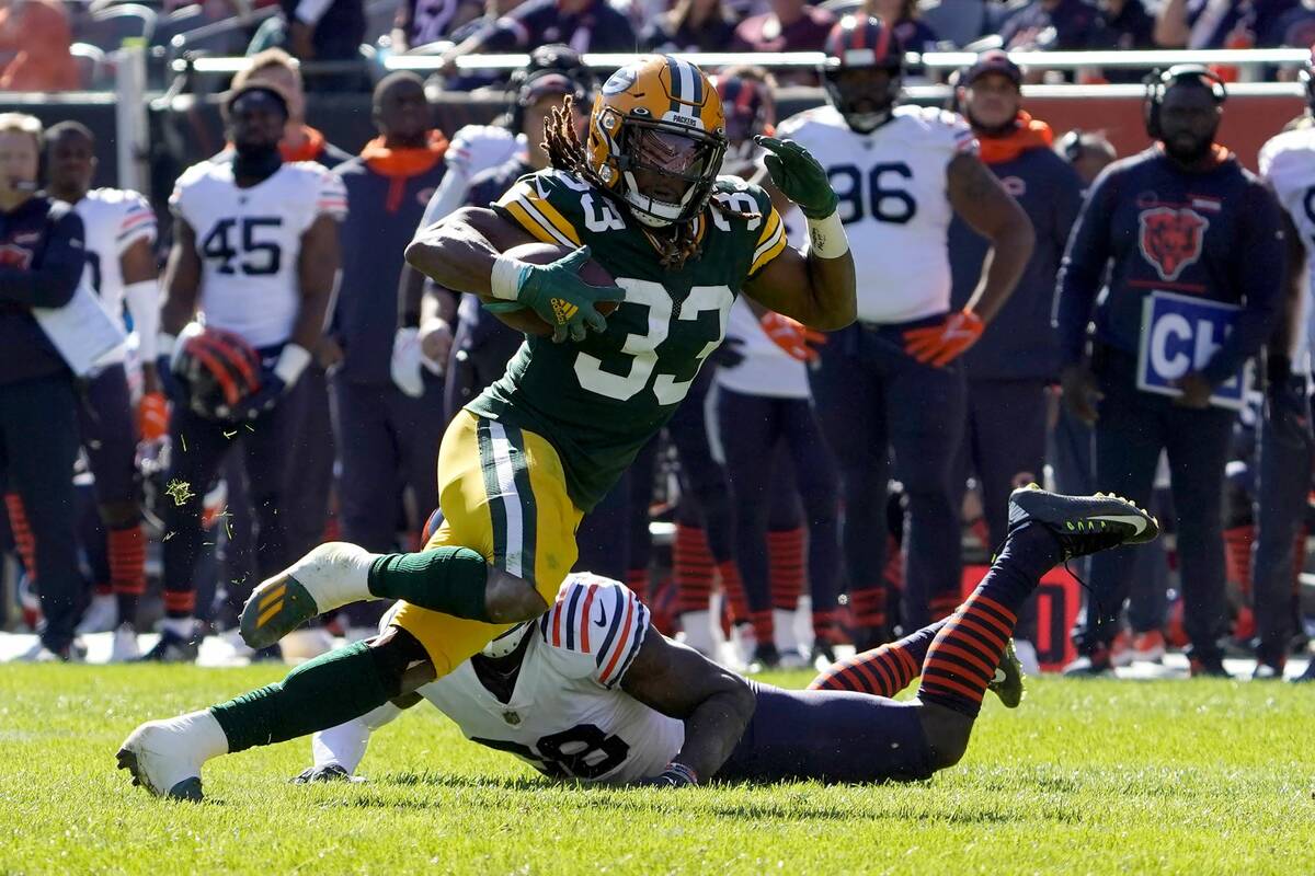 Green Bay Packers running back Aaron Jones heads to the end zone past Chicago Bears safety Tash ...