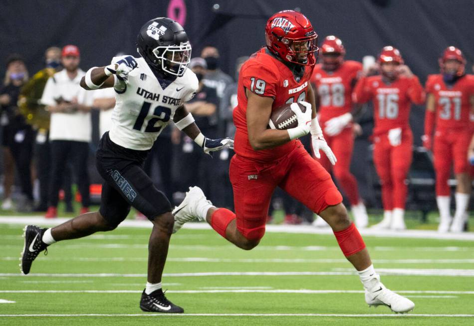 UNLV Rebels tight end Kaleo Ballungay (19) breaks off a big run past Utah State Aggies safety A ...