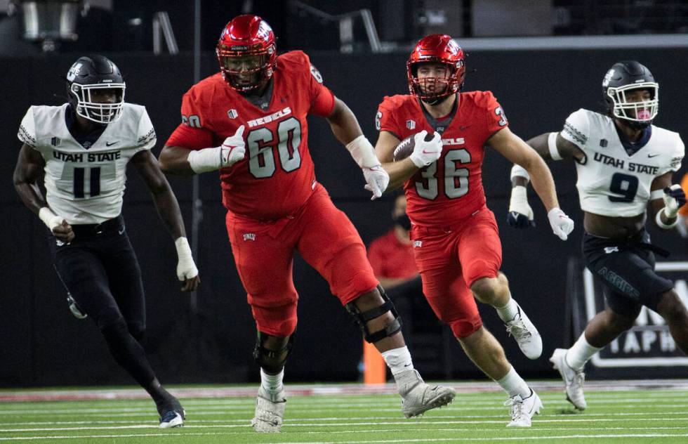UNLV Rebels running back Chad Magyar (36) rushes up field past Utah State Aggies defensive end ...