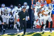 Raiders' interim head coach Rich Bisaccia runs onto the field with his players to face the Denv ...