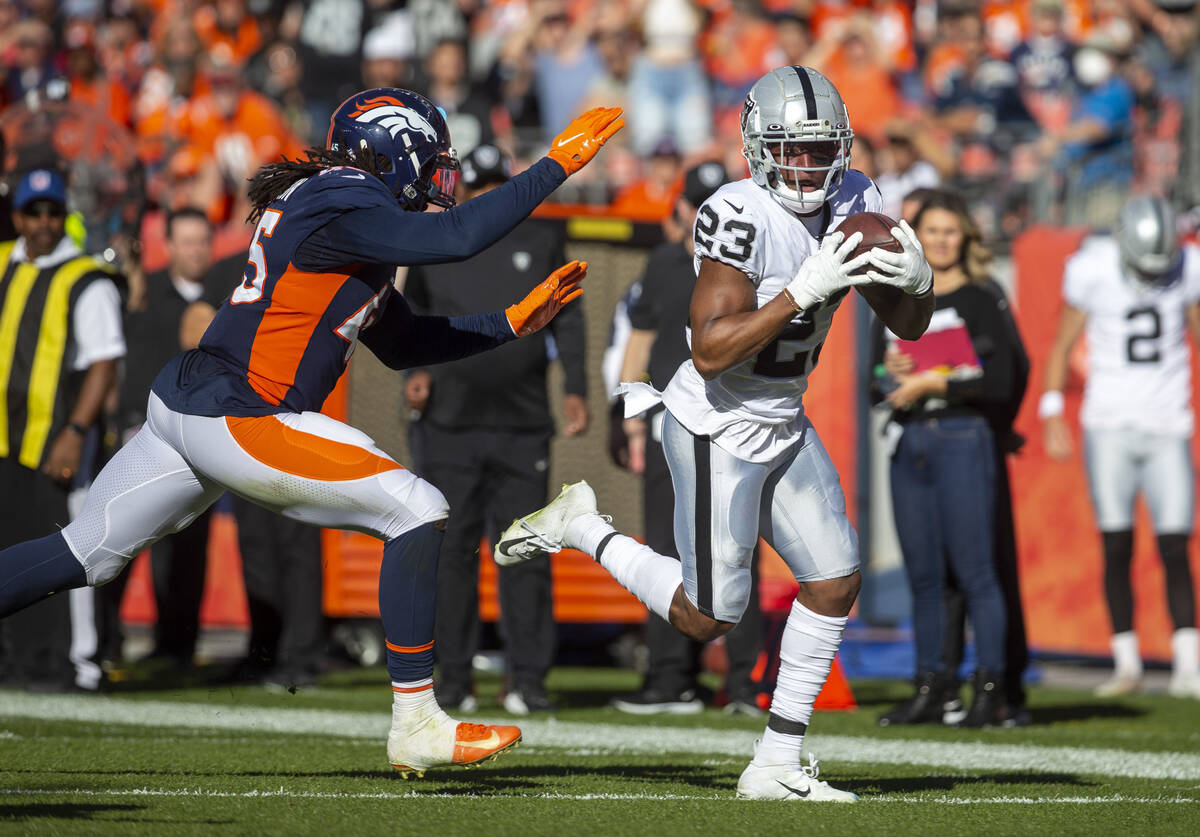 Raiders running back Kenyan Drake (23) runs past Denver Broncos inside linebacker A.J. Johnson ...