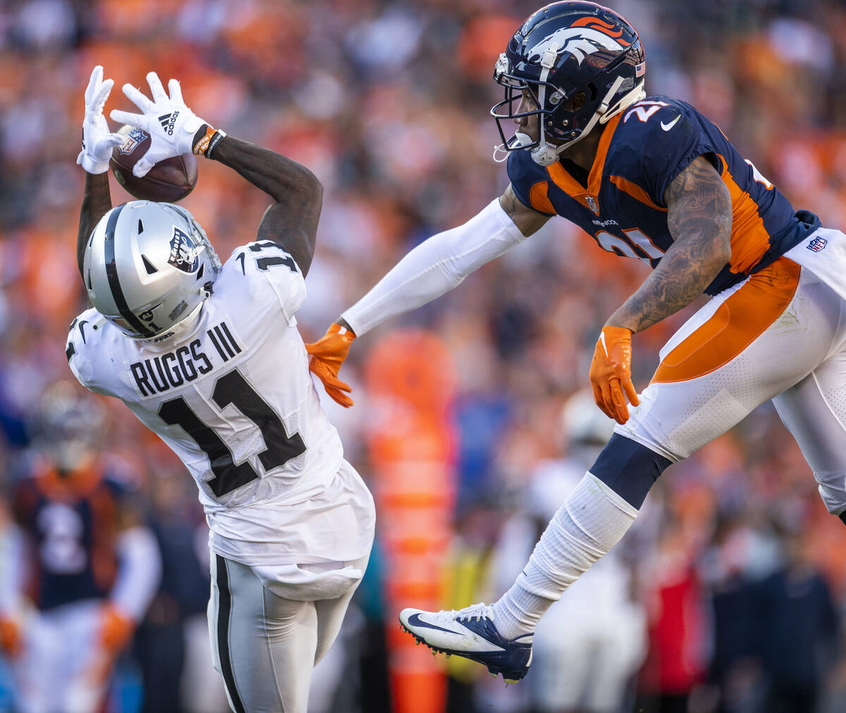 Raiders' wide receiver Henry Ruggs III (11) looks in a long pass over Denver Broncos cornerback ...