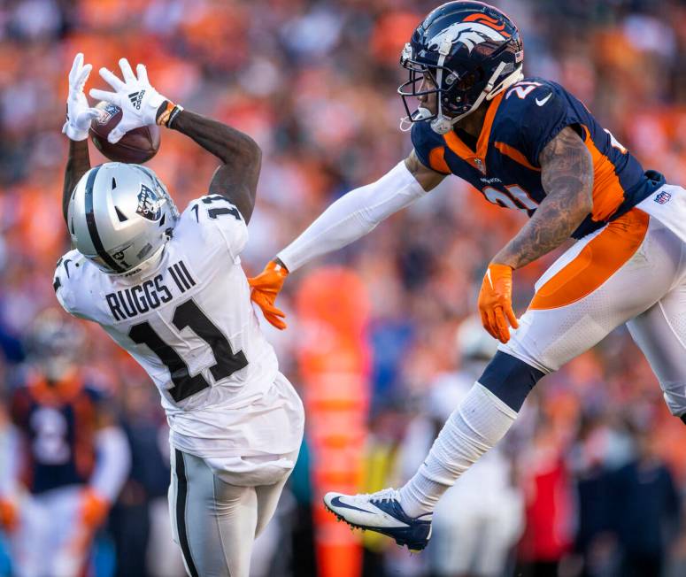 Raiders' wide receiver Henry Ruggs III (11) looks in a long pass over Denver Broncos cornerback ...