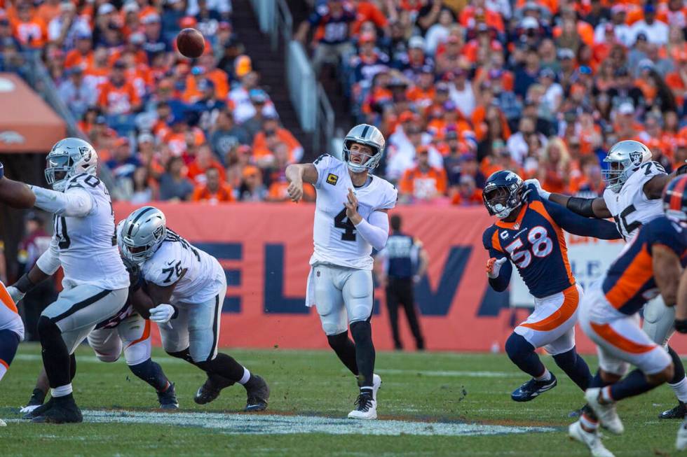 Raiders quarterback Derek Carr (4) throws as Denver Broncos outside linebacker Von Miller (58) ...